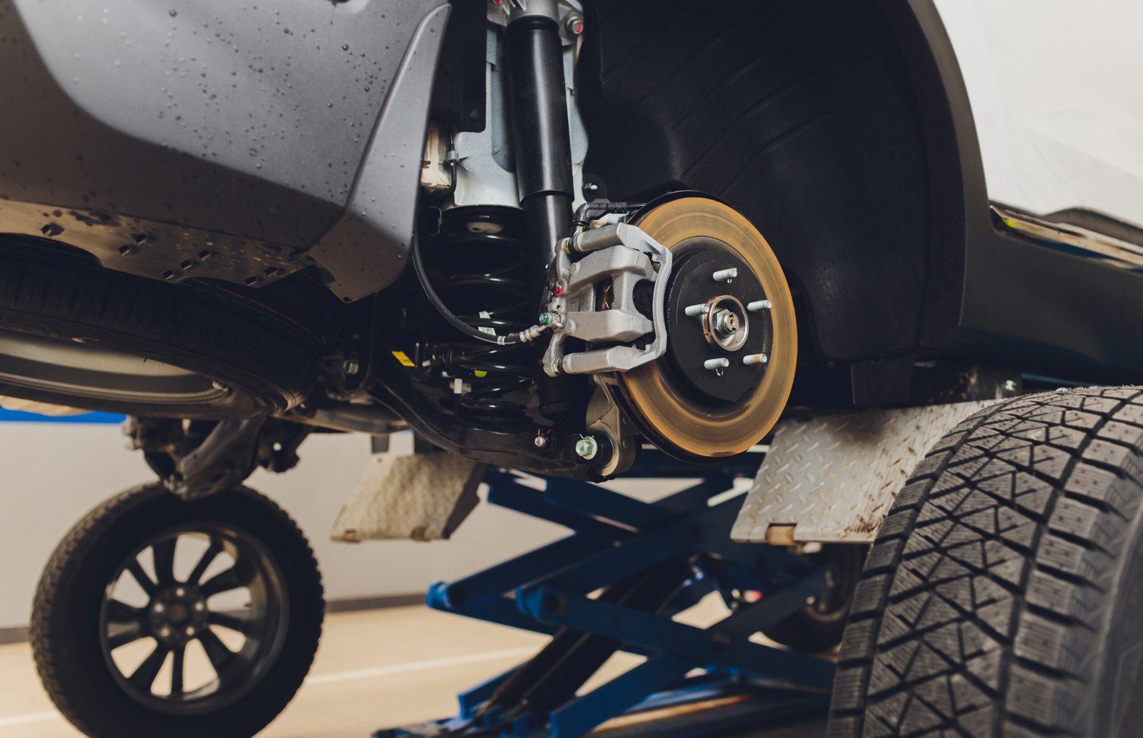 modern car service. back view of car in room service. Wheel replacement. Body shop. industrial background